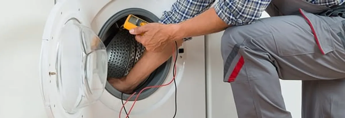 Dryer repair technician inspecting and repairing a clothes dryer in Seattle, WA