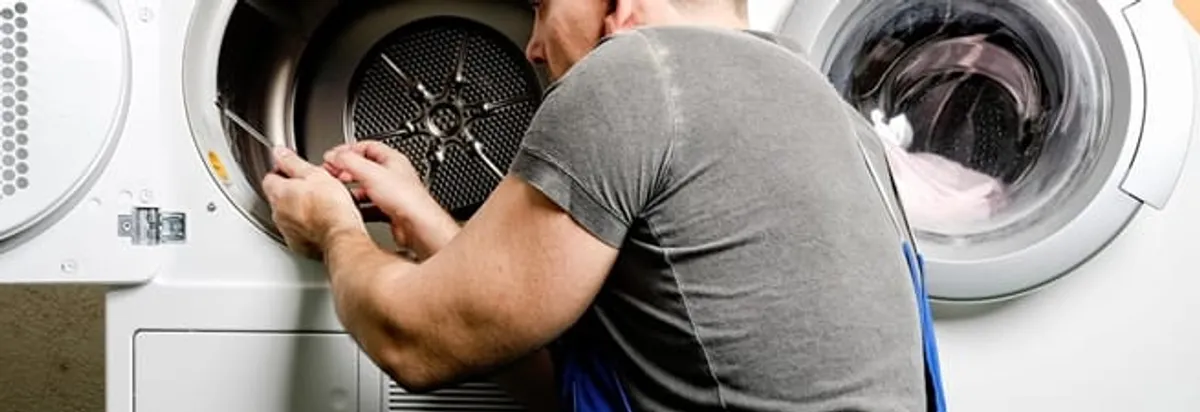 Dryer repair technician fixing a clothes dryer drum in Seattle, WA