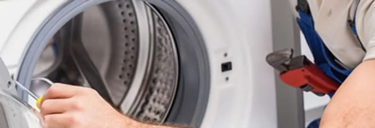 Appliance technician repairing a clothes dryer drum and internal parts in Seattle, WA