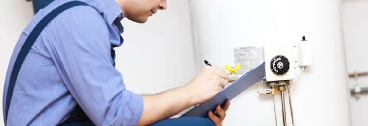 Water heater repair technician inspecting the unit and recording service notes in Seattle, WA